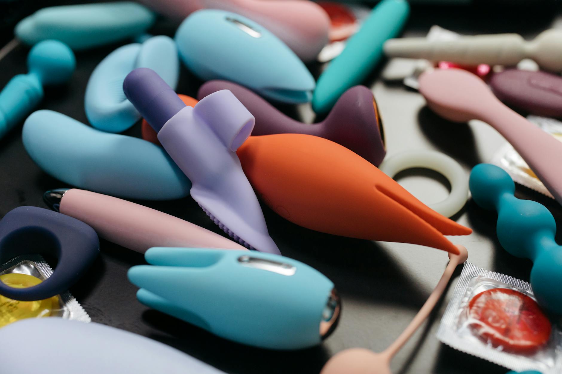 Una giovane coppia che si abbraccia affettuosamente, con un vibratore blu in primo piano che simboleggia l'intimità moderna e la ripresa della vita sessuale