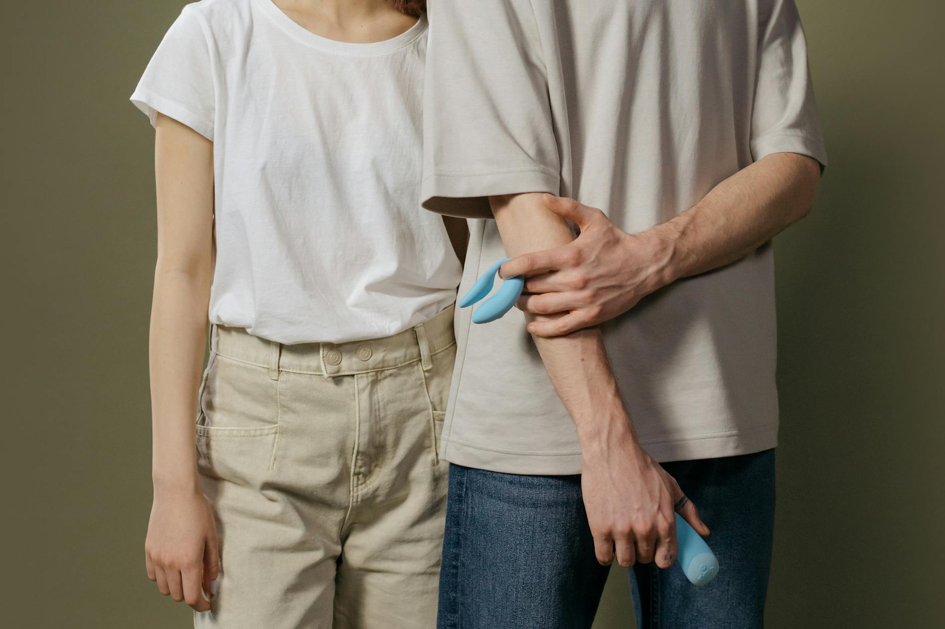 Una giovane coppia che tiene in mano un vibratore blu simboleggiante l'intimità moderna