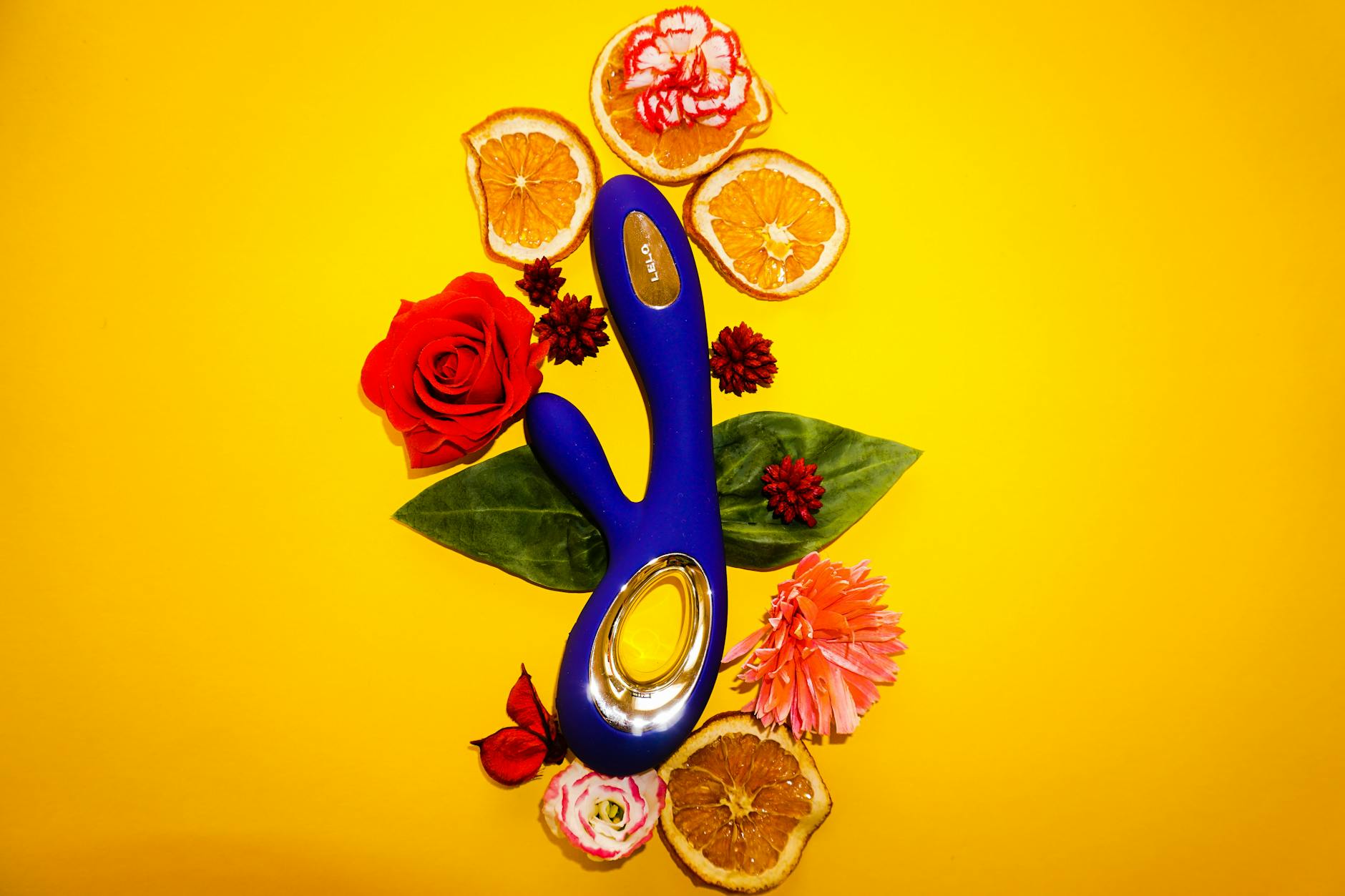 Due mani che tengono vibratori in silicone rosa e blu su uno sfondo pastello